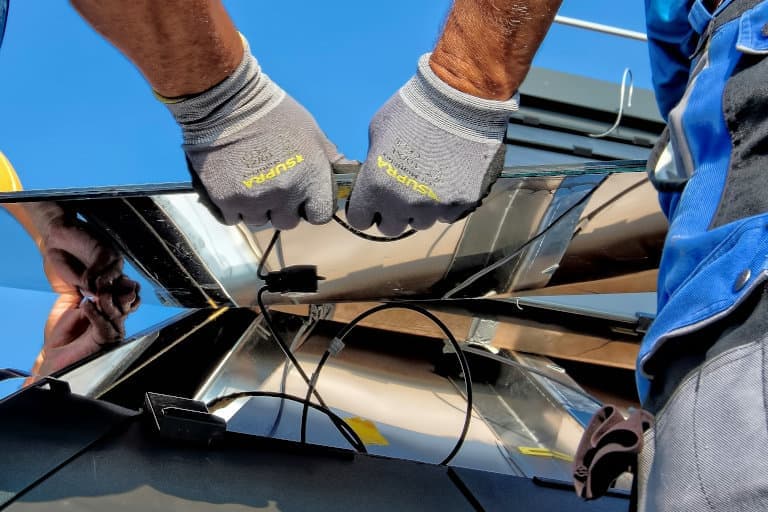Técnicos instalando un panel solar, representando energía renovable y trabajo especializado